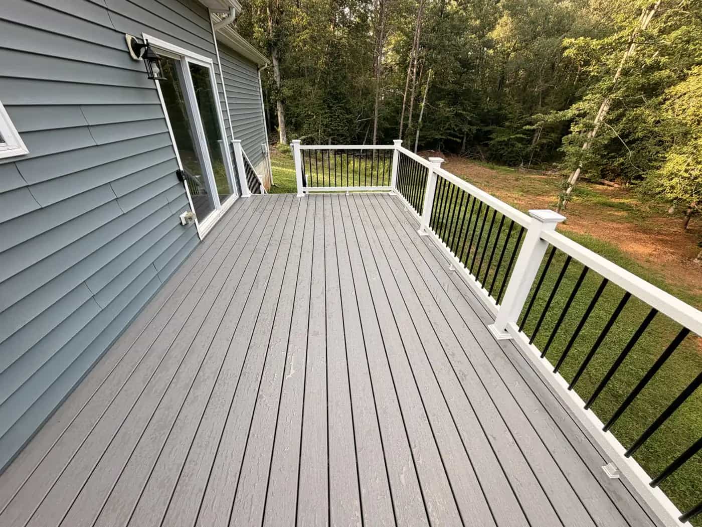 Finished Trex Pebble Beach composite deck surface with white rails and black balusters in Culpeper VA