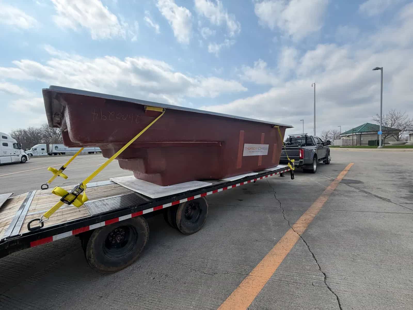 Fiberglass pool shell delivered on a trailer for a Thursday Pools project