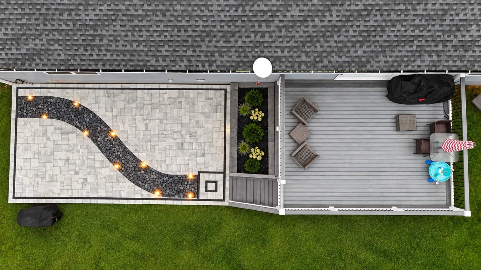 Aerial view of a Battlefield Services paver patio with a curved illuminated accent and adjoining composite deck in Spotsylvania, Virginia
