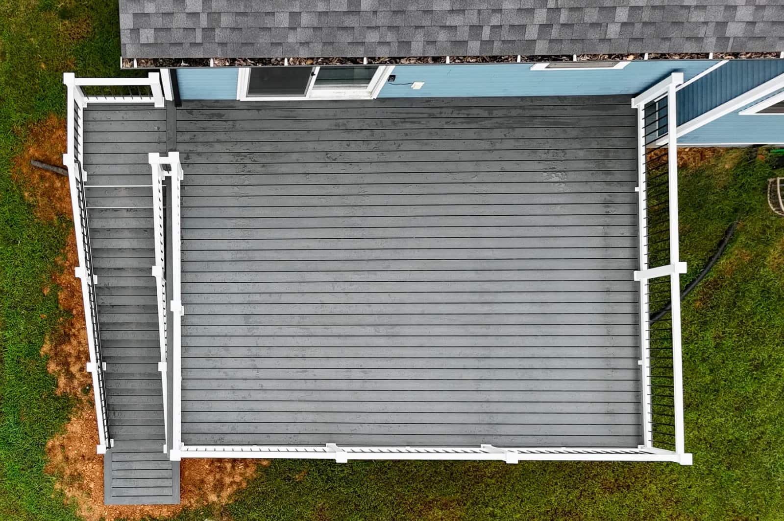 Overhead view of the gray Trex Enhance Clamshell deck surface and white perimeter railing