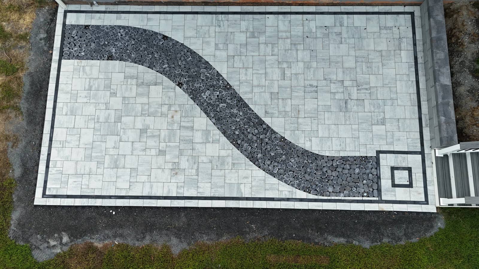 Aerial view of a Cheswick paver patio with a curved black cobblestone feature and square accent in Spotsylvania VA