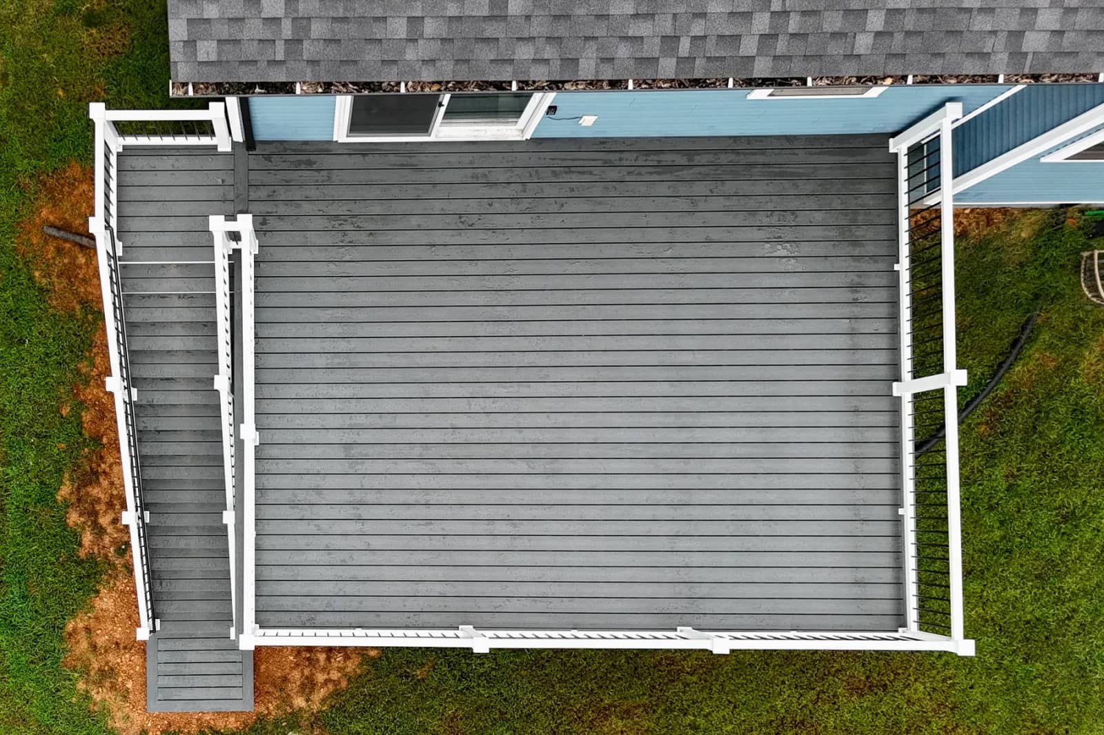 Overhead view of the gray Trex Enhance Clamshell deck surface and white perimeter railing