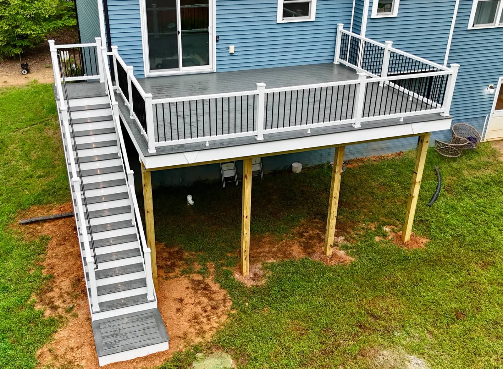 Completed elevated Clamshell deck with white rails, black balusters and matching stair landing