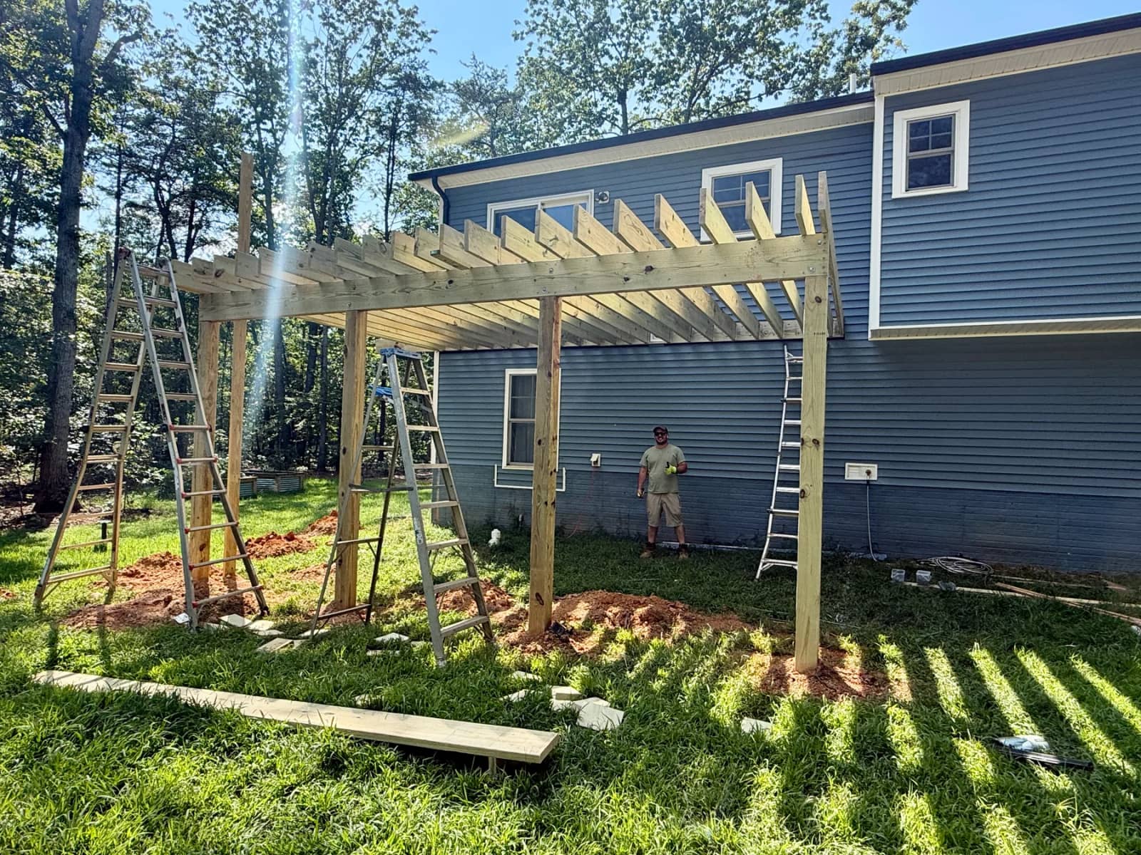 Construction progress showing elevated deck posts, beams and joists before decking