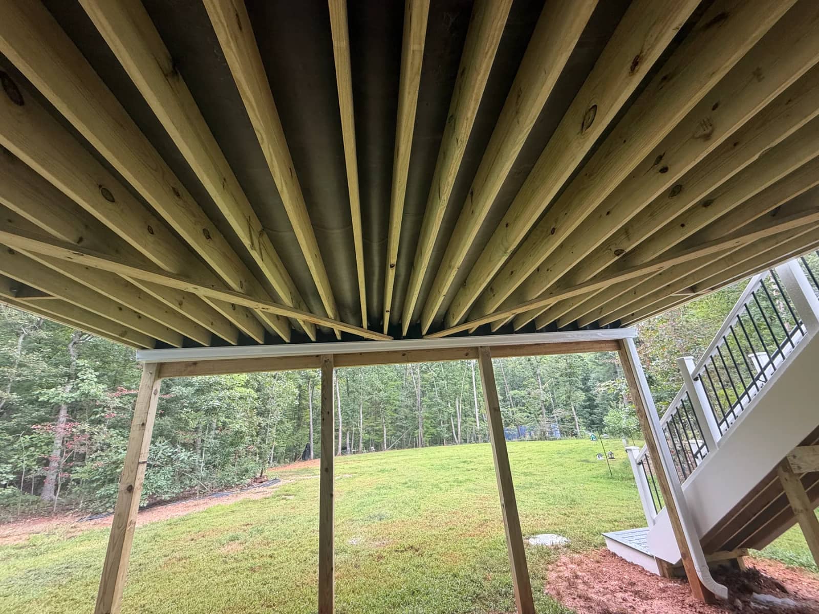 RainGuard drainage visible between the deck joists above the unfinished lower outdoor space