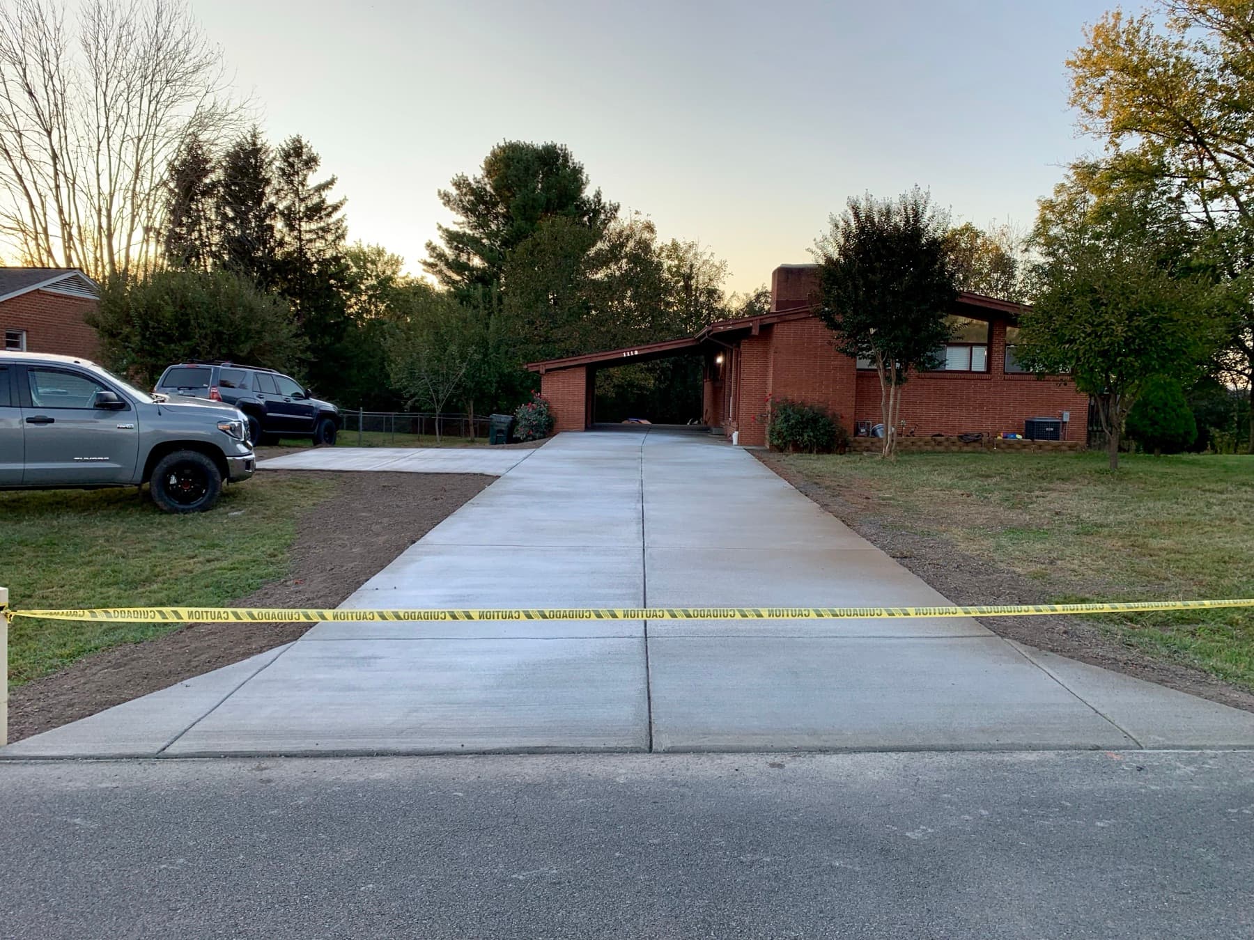 Finished broom concrete driveway with clean control joints leading to a brick home