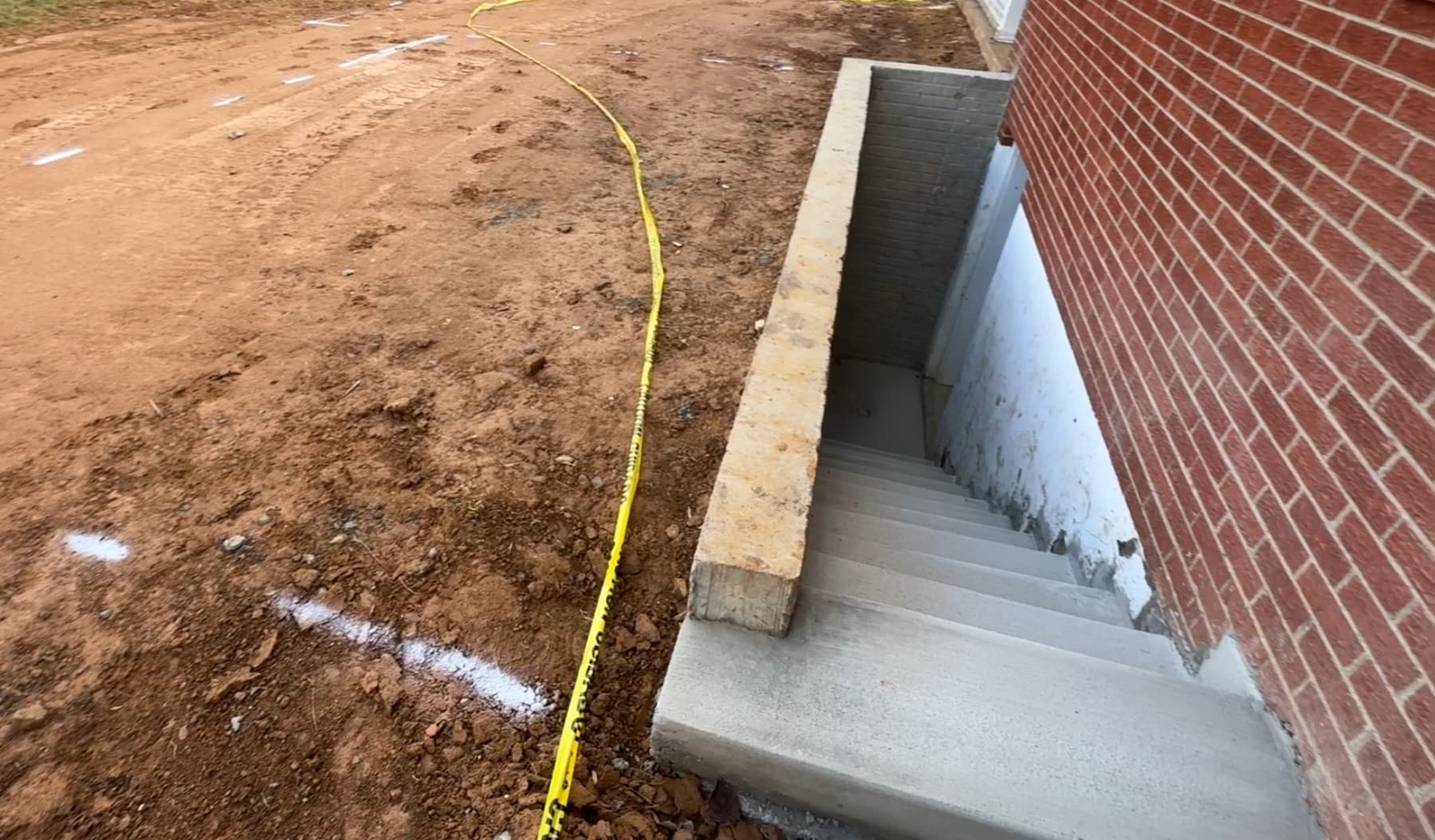 Finished basement egress entrance with concrete access and safety railing