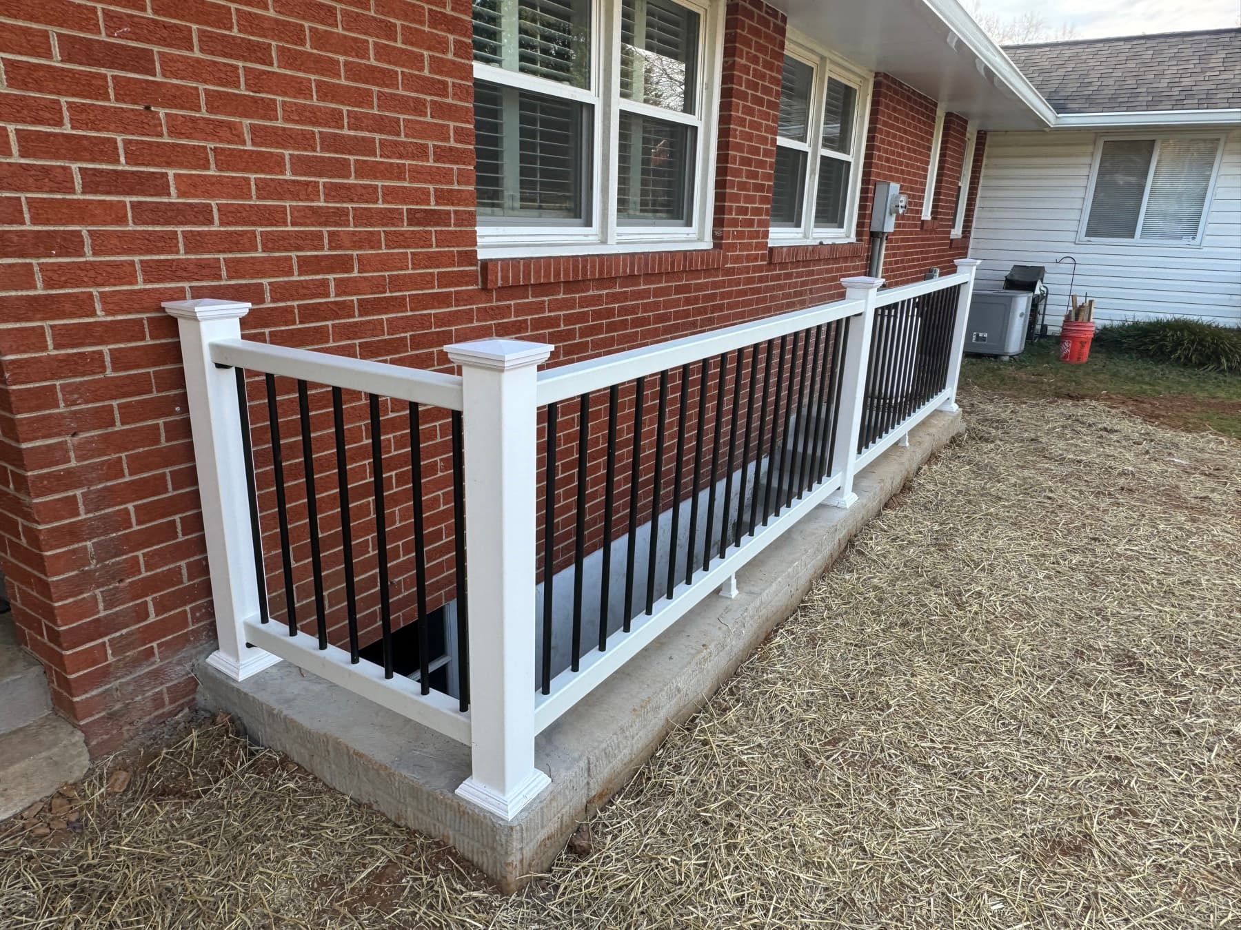 Finished basement egress entrance with concrete access and safety railing
