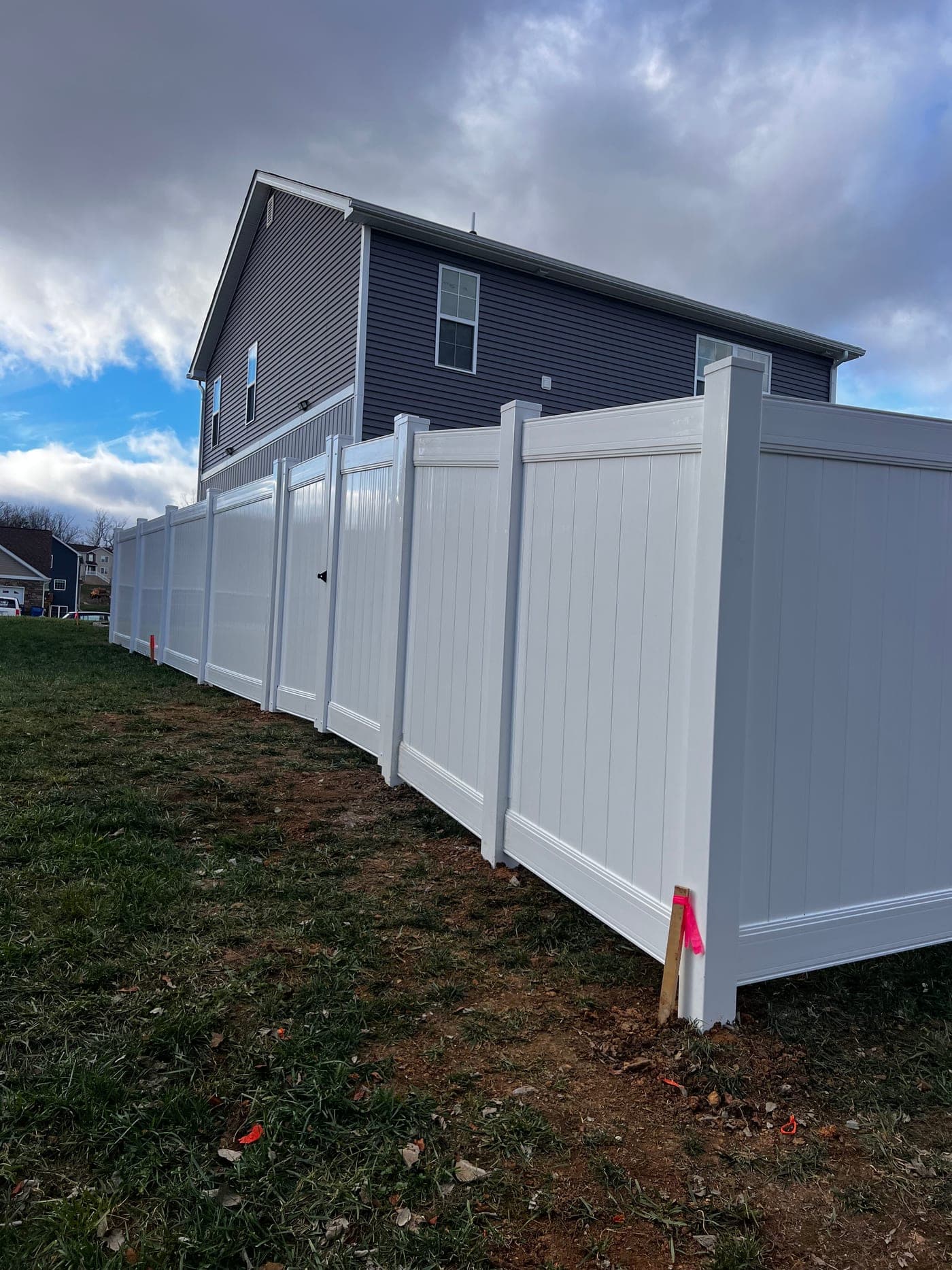 Long white vinyl privacy fence run along a side yard in Culpeper
