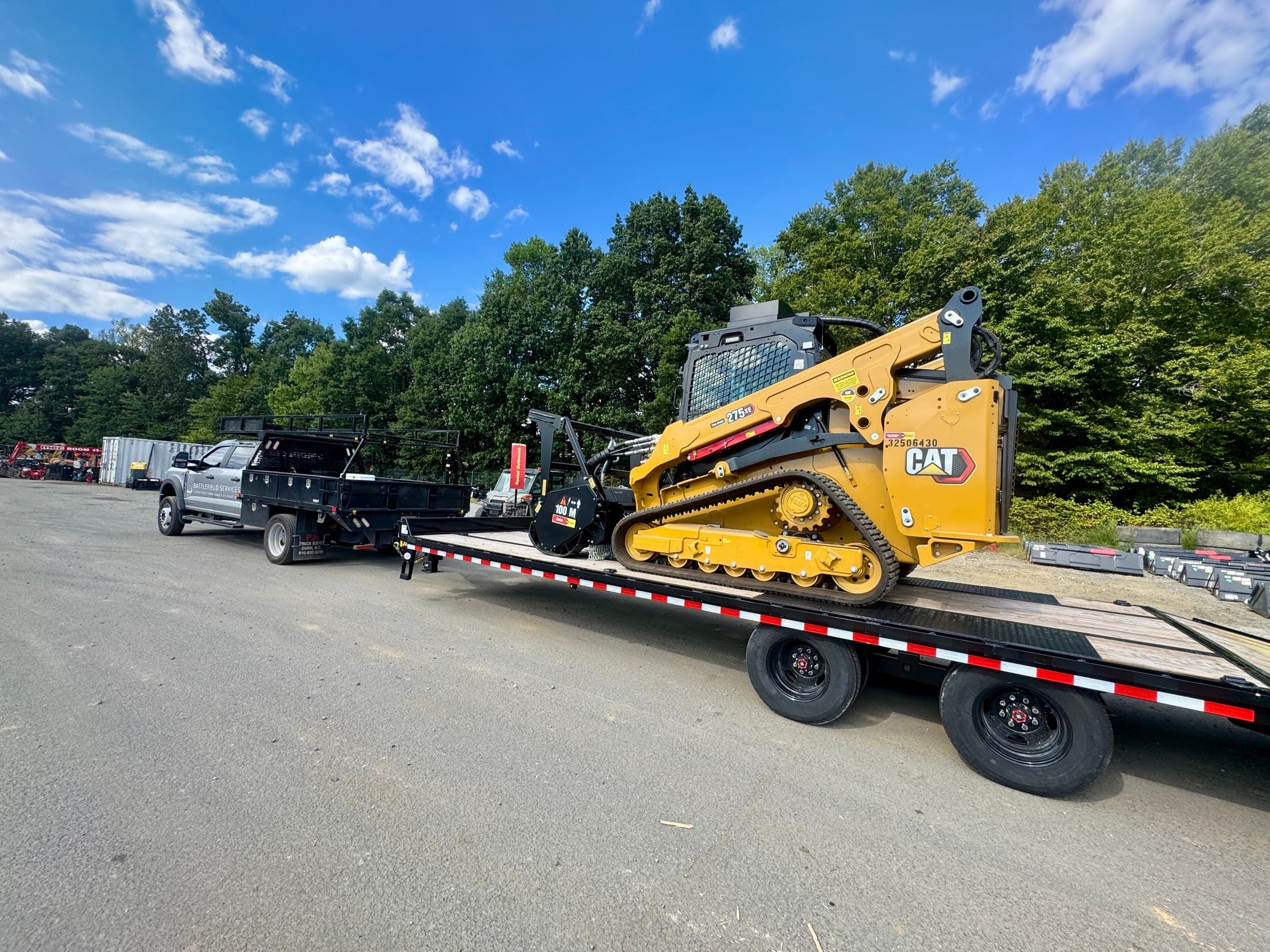 CAT 275 XE compact track loader with forestry mulching attachment on a trailer