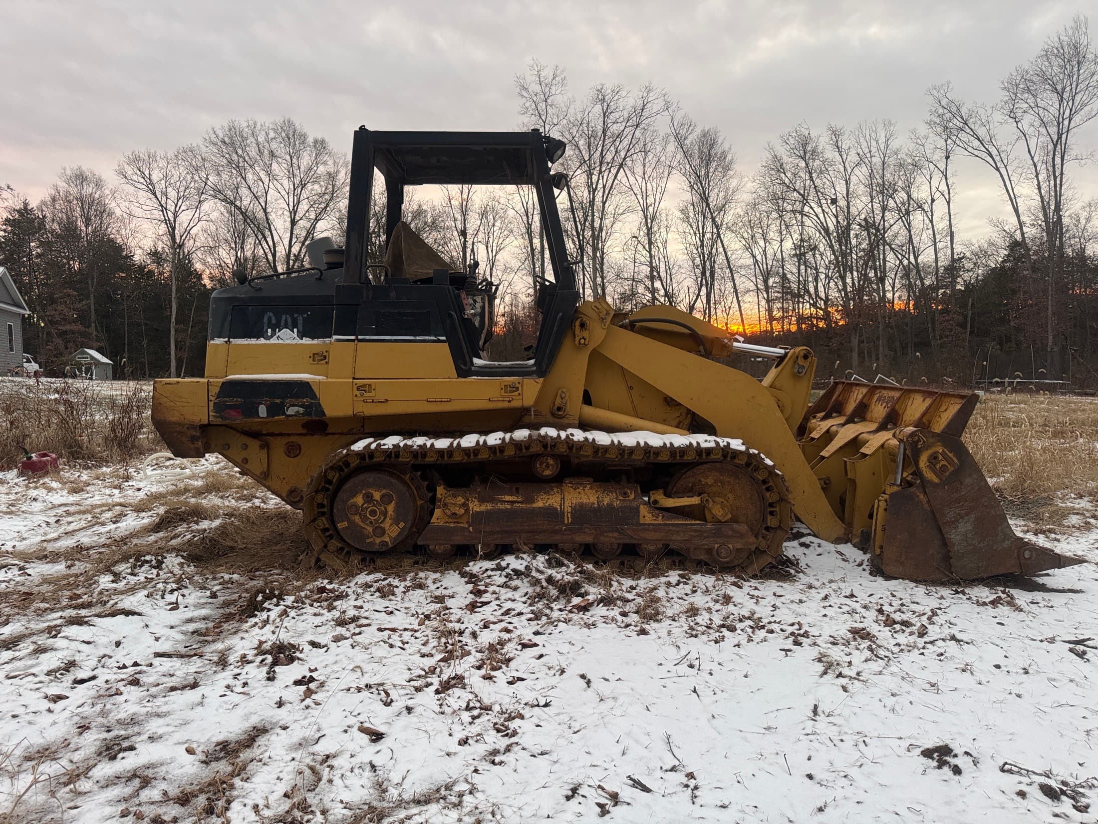 Tracked equipment on a snowy property for land clearing and site access work