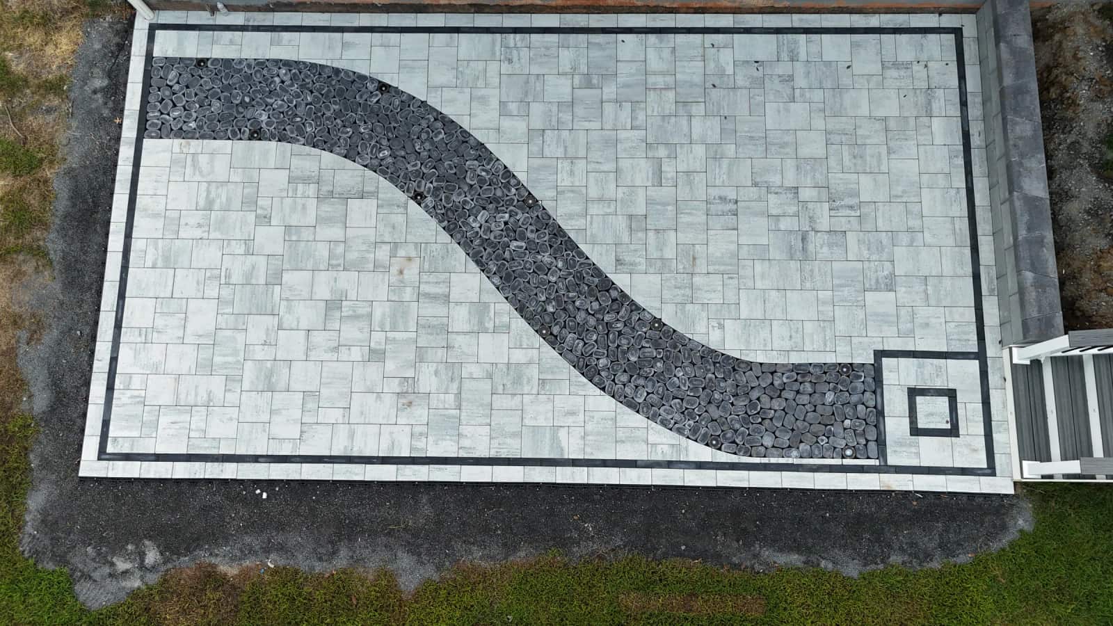 Aerial view of a Cheswick paver patio with a curved black cobblestone feature and square accent in Spotsylvania VA