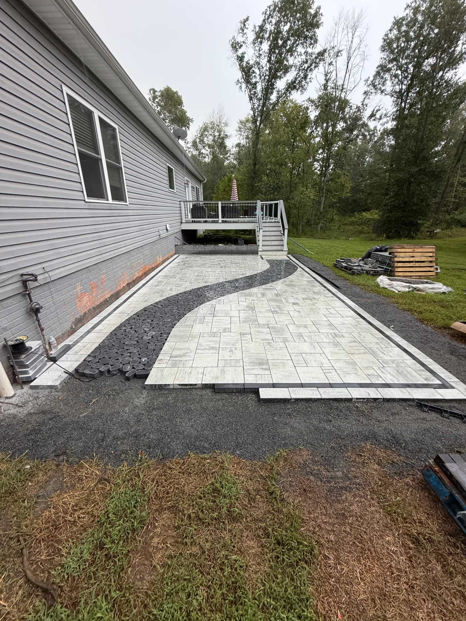 Ground-level view of the Cheswick paver field, curved black feature and perimeter border