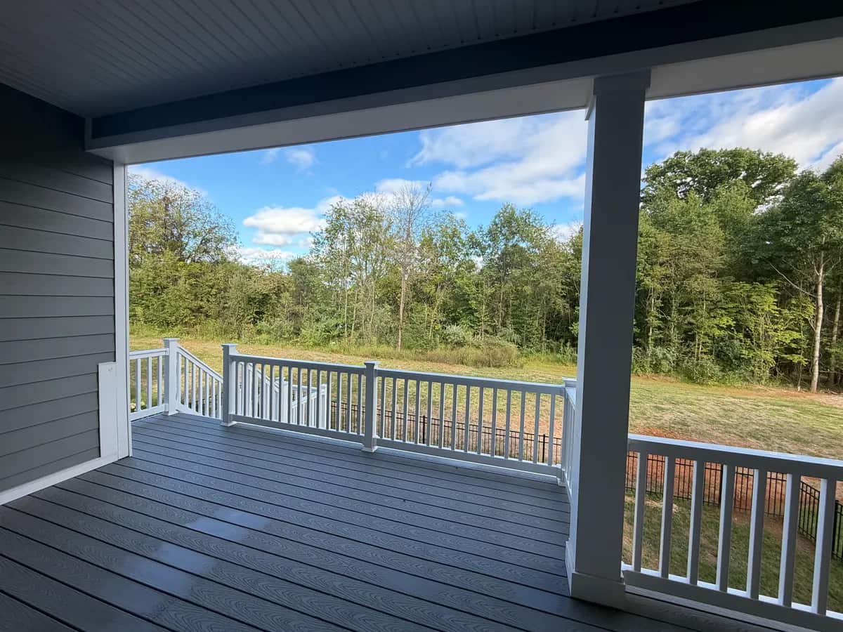 Finished deck surface and white railings beside the covered seating area