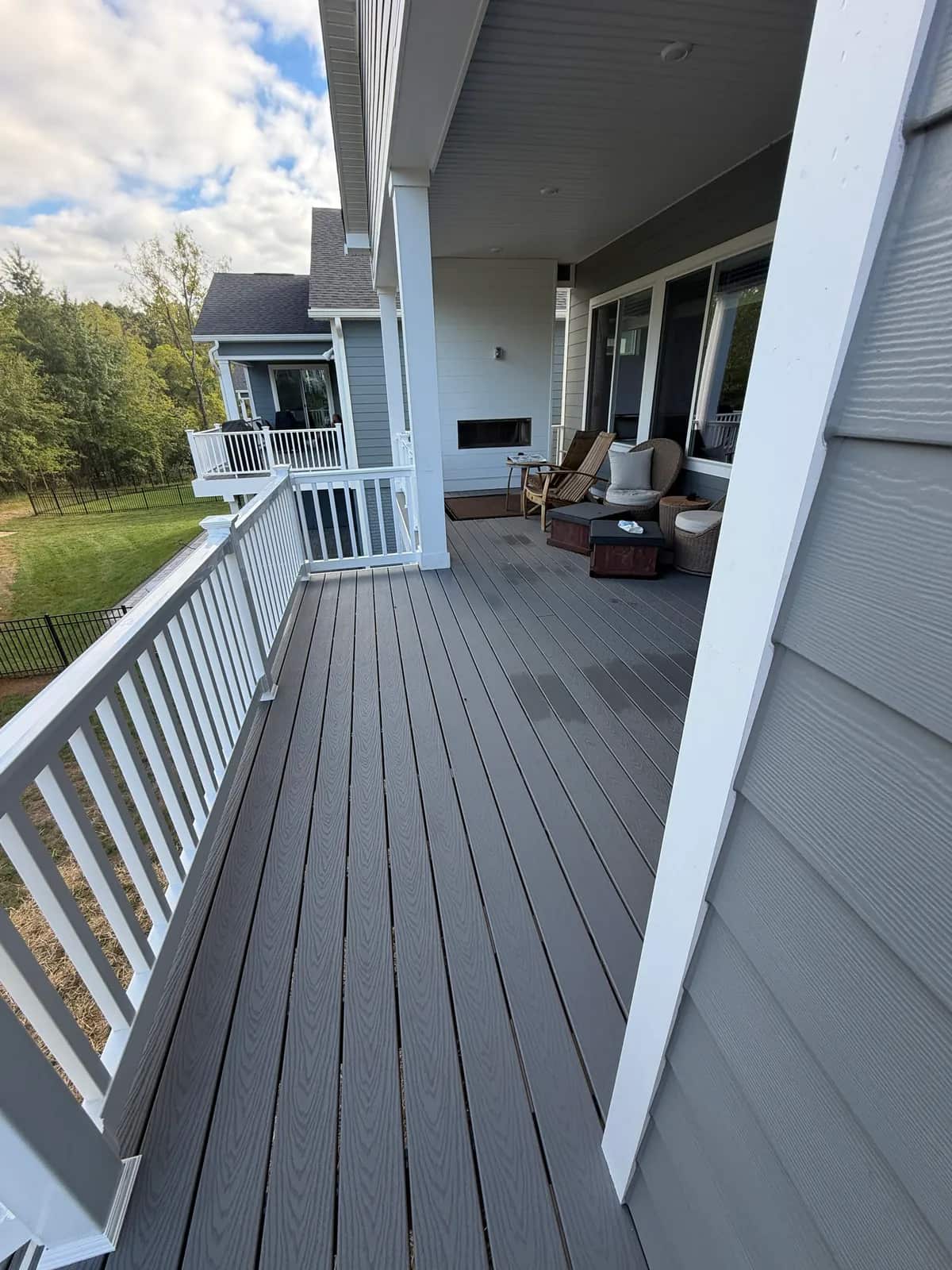 Finished detail: gray deck boards, white railing and the transition beside the house