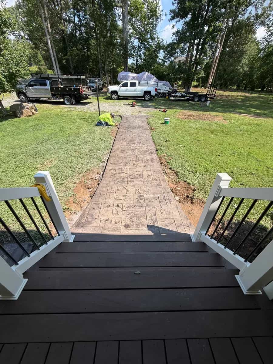 Finished stamped concrete sidewalk viewed from the front porch toward the driveway