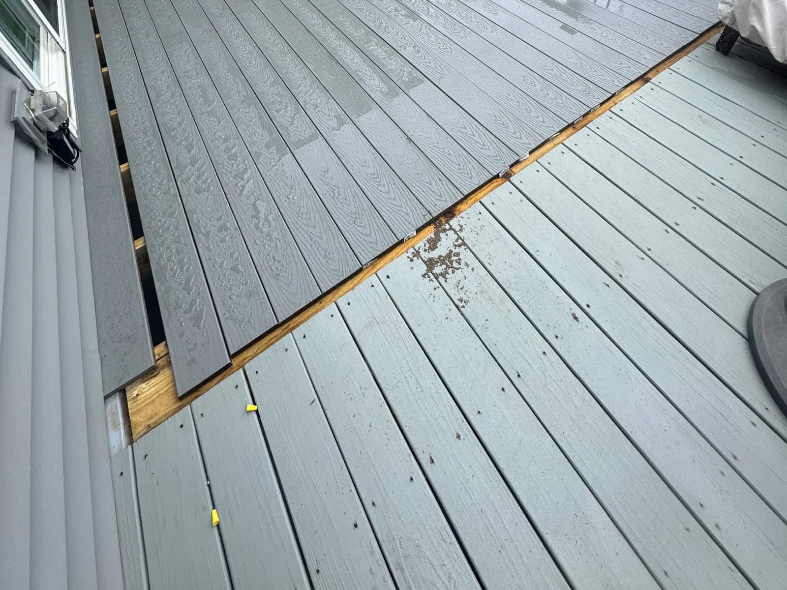 New Trex Select Pebble Grey boards beside remaining painted pressure-treated decking during resurfacing in Orange VA
