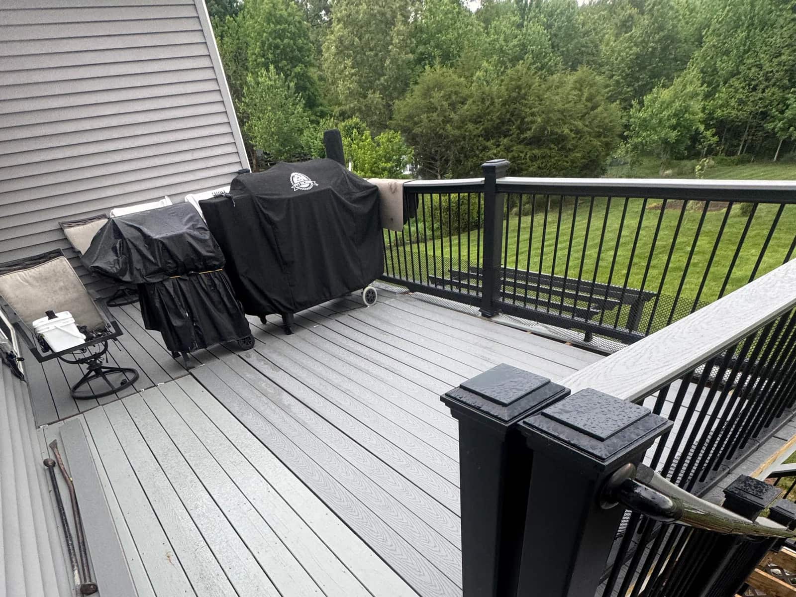 Completed Trex Pebble Grey deck surface fitted around retained black railing posts in Orange VA