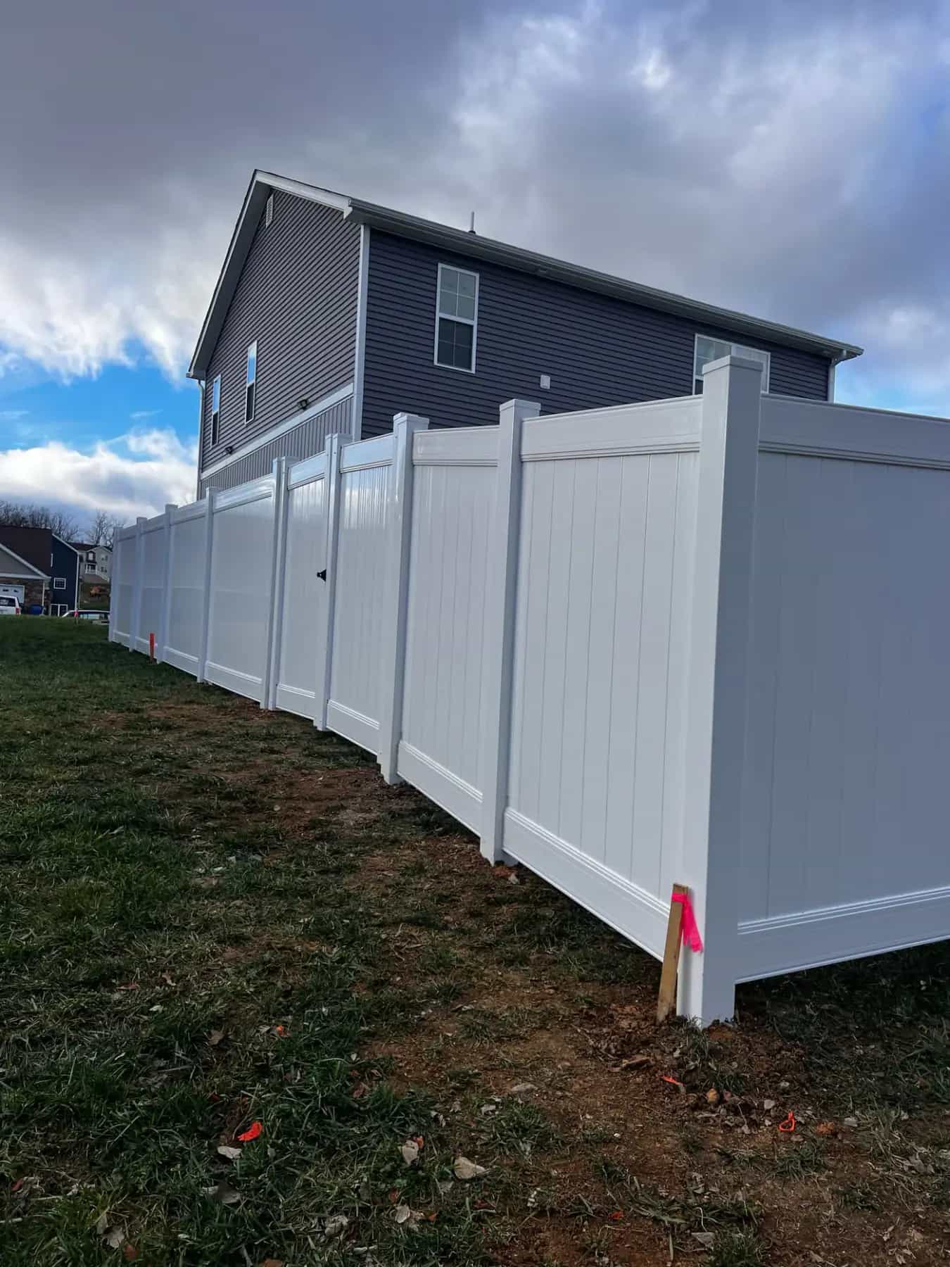 Long white vinyl privacy fence run along a side yard in Culpeper