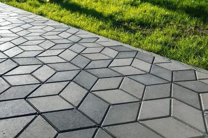 Finished paver patio surface with clean pattern and grass edge