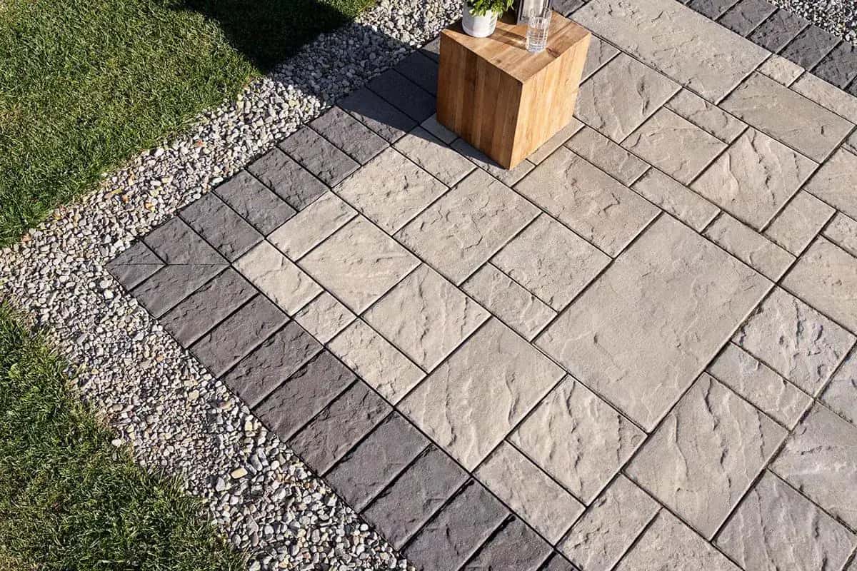 Finished paver patio surface with clean pattern and grass edge