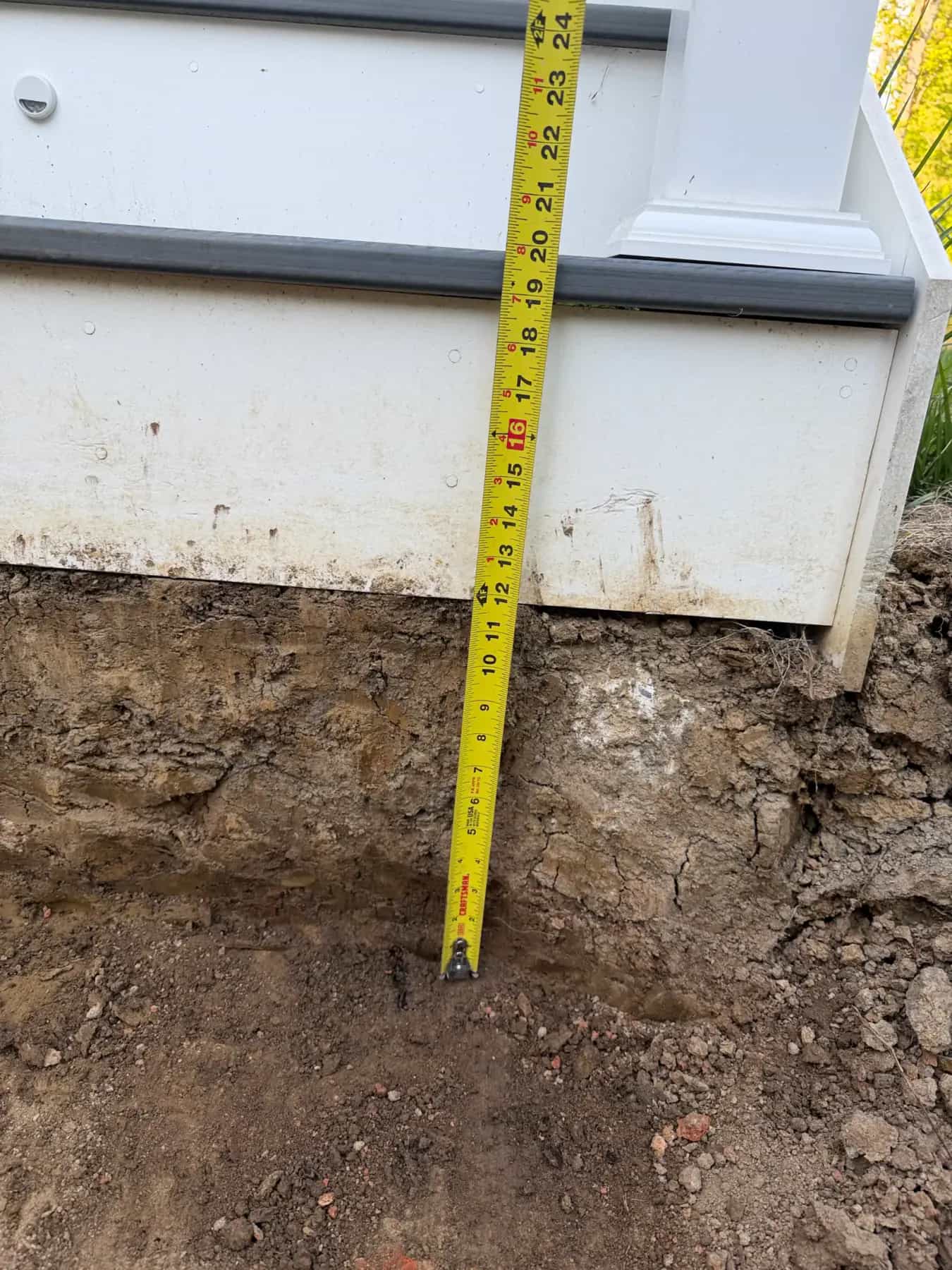 Paver walkway base depth check with measuring tape during patio and hardscape preparation